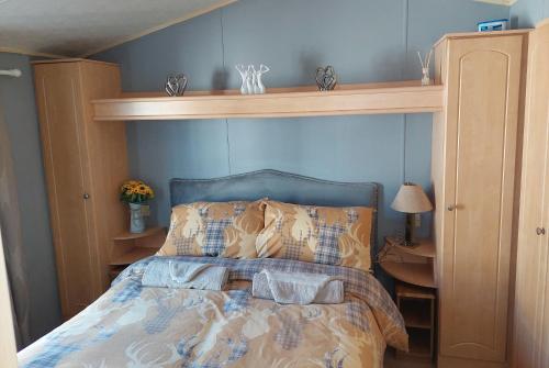 Saint CyrusWright Choice caravan rental 5 Lunan View St Cyrus Caravan Park的一间卧室配有一张带木制床头板的床