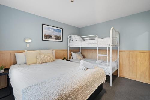 基督城Tasman Holiday Parks - Christchurch的一间卧室配有两张双层床和一张带双层床的床铺。