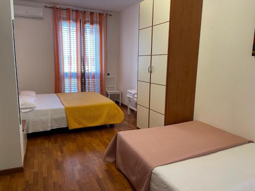 费尔莫Villa Alba的小房间设有两张床和窗户