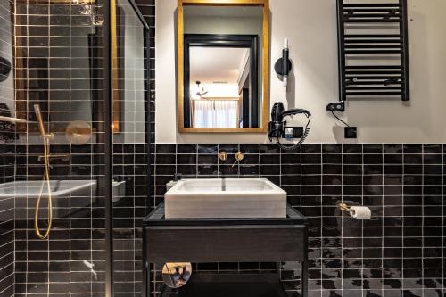 毕尔巴鄂Old Town Apartments by Staynnapartments的黑色瓷砖浴室设有水槽和镜子