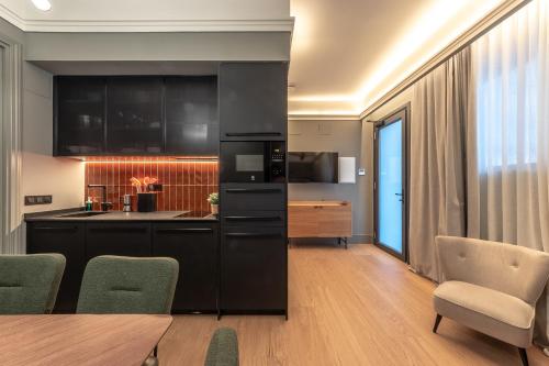 毕尔巴鄂Old Town Apartments by Staynnapartments的厨房配有黑色橱柜和桌椅