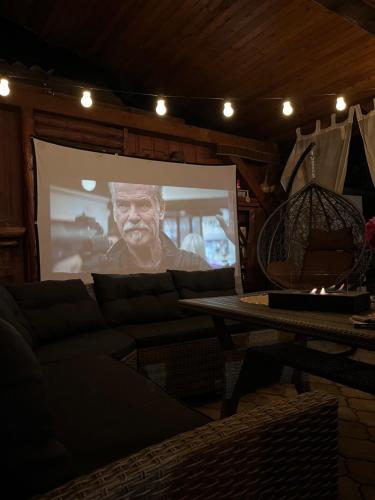 比哈奇Guest House Eden的客厅的电影屏幕,配有沙发