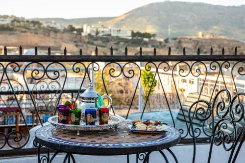 非斯Dar Amir Fez的阳台上桌子上的托盘食物