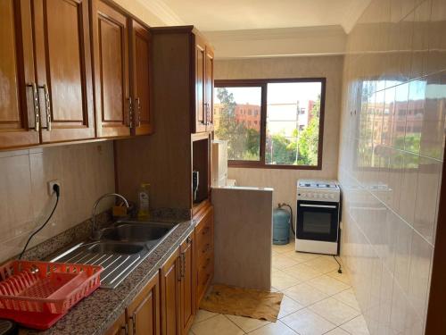 马拉喀什Superbe appartement à Marrakech quartier Majorelle 2 chambres的厨房配有水槽、炉灶和窗户。