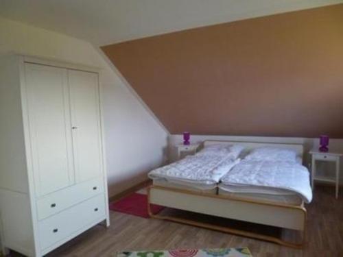 齐罗Ferienhaus in Hoben mit Grill und Terrasse的一间卧室配有床和白色橱柜