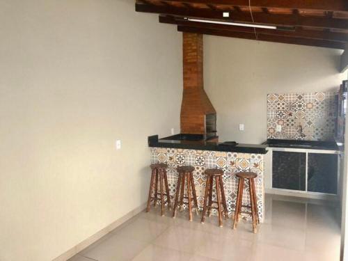阿拉沙Casa aconchegante em Araxá的厨房配有三把凳子和台面