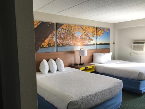 国际瀑布城Days Inn by Wyndham International Falls的酒店客房设有两张床,墙上挂有绘画作品