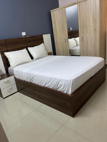 瓦加杜古Glorymienmo的一间卧室配有一张带白色床单的大床