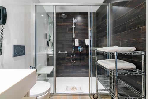 阿德耶阿德里安科隆瓜纳哈尼成人酒店的浴室里设有玻璃门淋浴