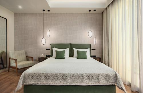 雅典The Residence Christokopidou Hotel & Spa的一间卧室配有一张大床和一把椅子