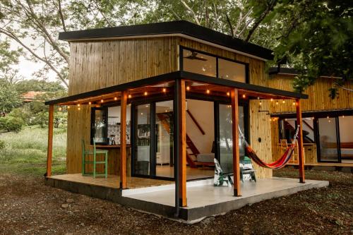 普拉纳维瑙Tiny Homes Venao Cove的玻璃门的房子,周围是红色绳子