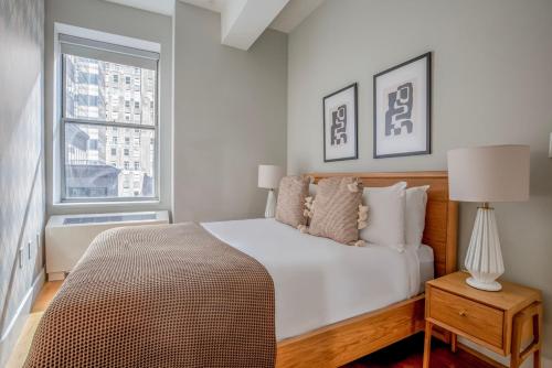 纽约FiDi 1BR w luxury Gym Doorman Rooftop NYC-13的白色的卧室设有床和窗户