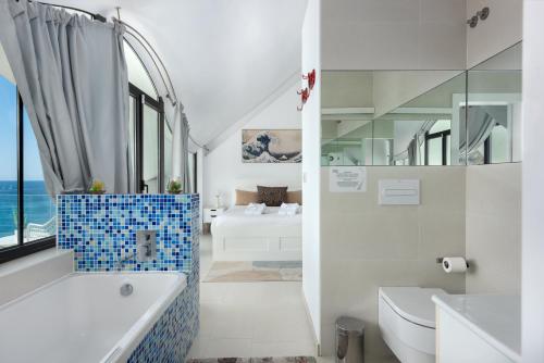 格拉纳达RentitSpain Casa Acantilado的带浴缸、卫生间和盥洗盆的浴室