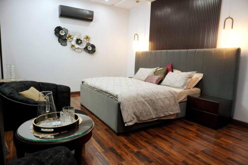 拉合尔Newly built Villa in Lahore的一间卧室配有一张床、一把椅子和一张桌子
