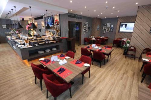 富查伊拉Fortis Hotel Fujairah的一间带桌椅的餐厅以及一间自助餐