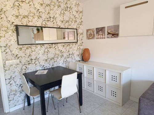 滨海普雷米亚Precioso Dúplex con terraza a 5 minutos playa y 20 minutos de Barcelona的一间用餐室,配有黑桌和白色椅子