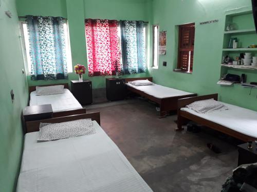 kolkataPushpak Guest House Boys, Near DumDum metro Station的带三张床和两扇窗户的房间