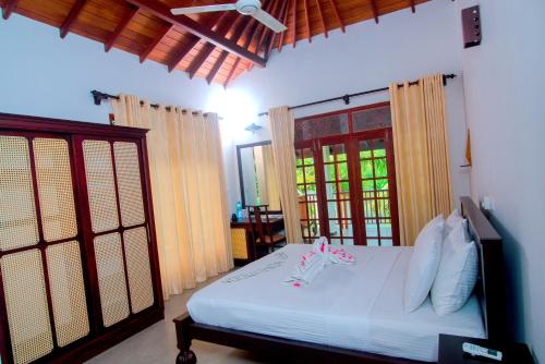 本托塔Lagoon Bentota Resort的卧室配有白色的床和窗户。