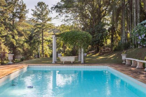 伊塔蒂巴Casa de Vidro com cachoeira的庭院内的游泳池,配有浴缸