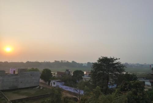 瓦拉纳西Goroomgo Hotel Kashi Nest Varanasi - A Peacefull Stay & Parking Facilities的城市景观,背景是日落