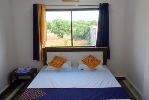 瓦拉纳西Goroomgo Hotel Kashi Nest Varanasi - A Peacefull Stay & Parking Facilities的一间小卧室,配有一张带窗户的床