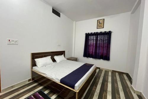 瓦拉纳西Goroomgo Hotel Kashi Nest Varanasi - A Peacefull Stay & Parking Facilities的一间卧室设有一张床和一个窗口