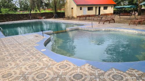 Premara Hotel Kehancha的大型游泳池铺有瓷砖地板。