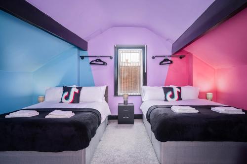 BalbySocial Media Adventure - 3 Bedroom - City Centre - Doncaster的紫色的客房设有两张床和一扇窗户。
