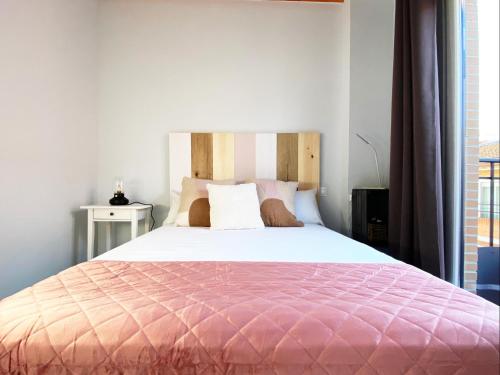 马德里Las Barajas de Saturno的一间卧室配有一张带粉红色棉被的大床