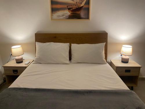 雷夫卡达镇lividio apartment的一间卧室配有一张带两张台灯的床铺。