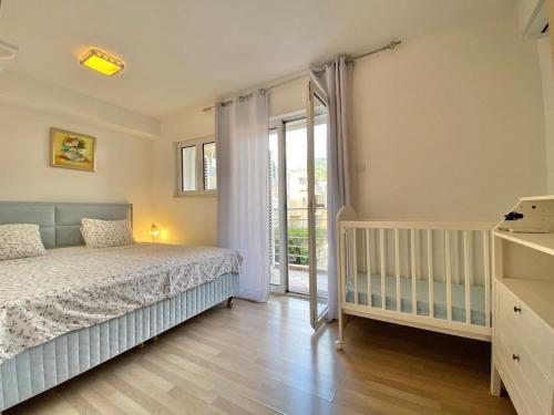 比耶拉Apart Hotel Apple Cat Montenegro KO Bijela的一间卧室设有一张床和一个滑动玻璃门