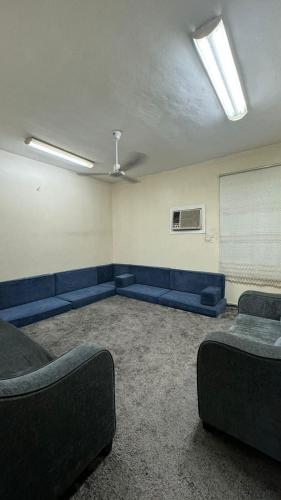 Az ZāhirRoom and Bath Only的一间设有蓝色沙发和白色板的等候室