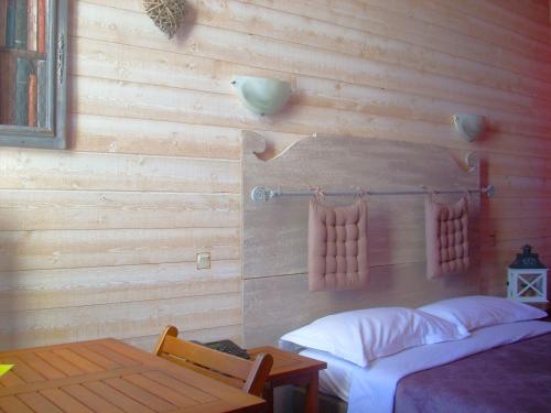 南特城堡酒店的一间卧室设有木墙、两张床和一张桌子