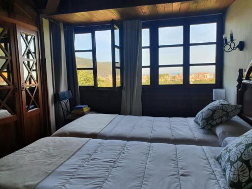 San Juan de la ArenaComplejo turístico Las Mimosas del Nalon, LOS NOVALES的一间卧室设有一张大床和一个窗户。