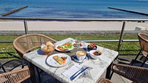 奥斯赛拜-屈隆斯博恩meergut HOTELS的一张带餐盘的桌子,享有海滩美景