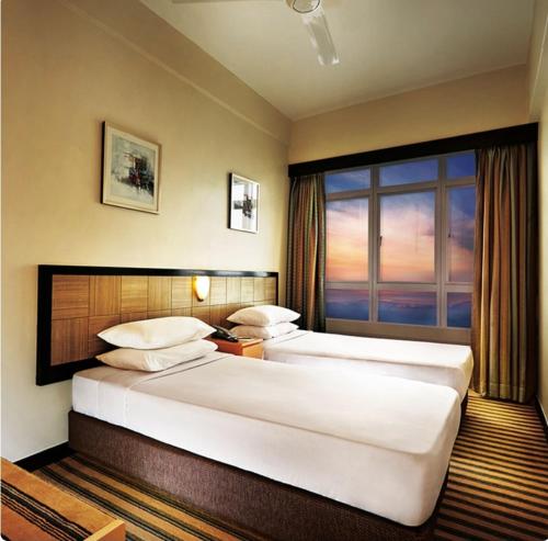 云顶高原First World Hotel的配有窗户的酒店客房内的两张床