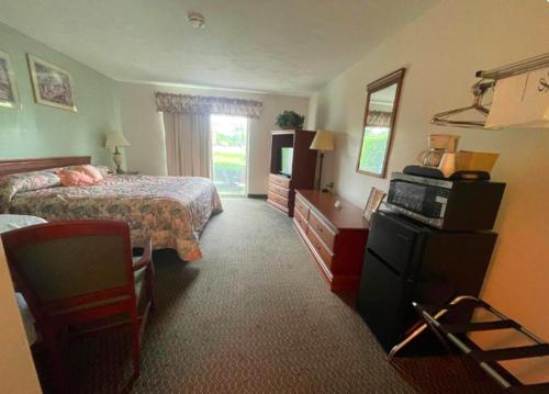 SusquehannaColonial Brick Inn & Suites的酒店客房,配有床和电视