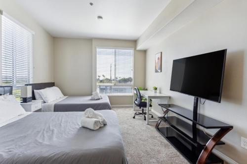 洛杉矶Modern 2bedroom Apartment with Pool的一间卧室配有两张床和一台平面电视