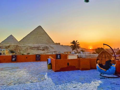 开罗Energy Of Pyramid Hotel的坐在金字塔前椅子上的女人