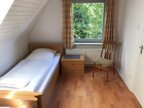 叙德尔吕古姆Mühlenweg- Tante Lise的一间小卧室,配有一张床和一把椅子