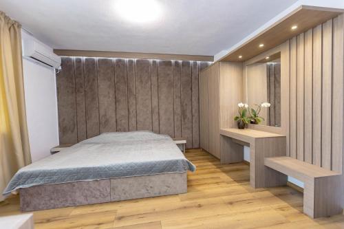 桑丹斯基Family Hotel Ambrozia的一间卧室配有一张床,铺有木地板