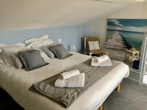 波尔多La loge des Salinières的一间卧室配有一张大床和毛巾