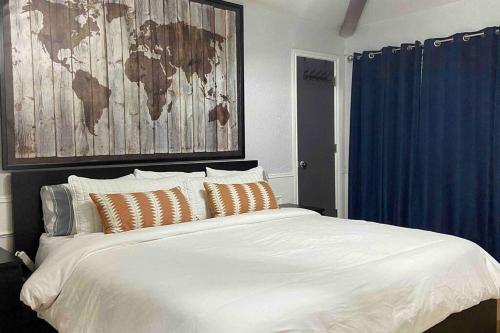 达拉斯Vacation Home with Private Pool的卧室配有一张大白色床,墙上挂有地图