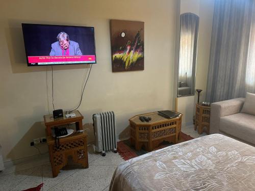 马拉喀什Appartement Wassim - Gueliz的一间配有电视的壁挂式客房,配有一张床
