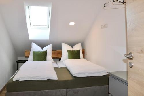 克伦巴赫Moderne DG-Wohnung im Günztal的一间卧室配有带绿色和白色枕头的床