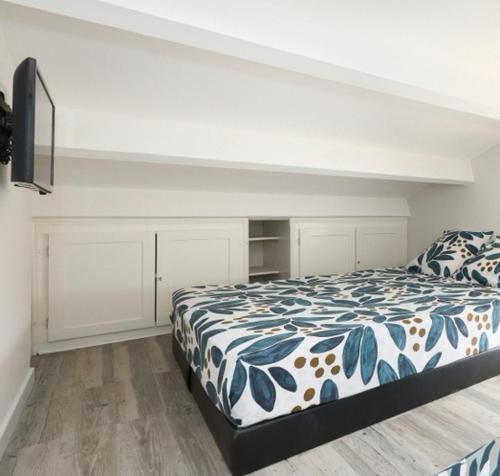 圣西普里安Fare Laurent的一间卧室配有一张带蓝色和白色棉被的床