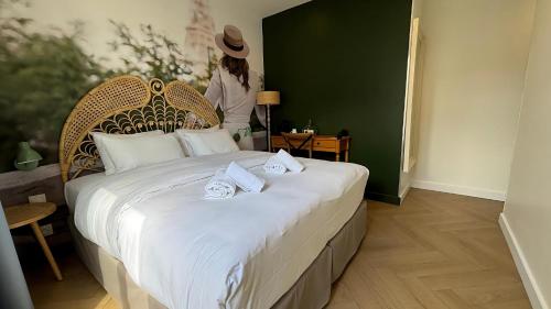 巴黎格南的酒店的一位妇女站在一张大床上,上面有毛巾