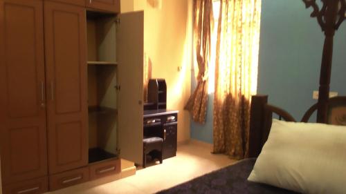 FumbaFumba House BnB的一间卧室配有一张床和一个带电视的橱柜