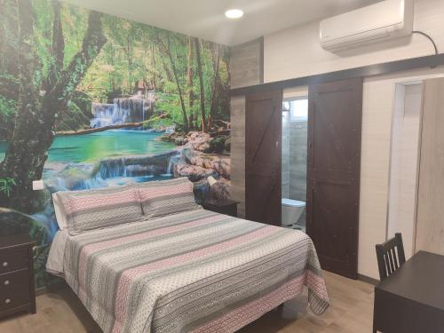 托莱多Hostal El Bosque Encantado Toledo的卧室配有一张壁挂瀑布壁画的床。