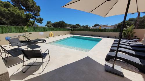 卡拉恩·布拉內斯Villa Victoria Paradise的一个带椅子和遮阳伞的游泳池